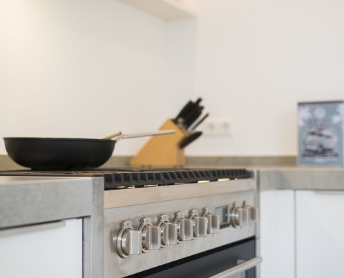 Strakke witte keuken met rvs grepen bij Zenner Keukens IJsselstein